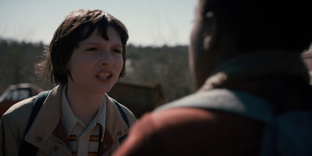 Medium shot frame from Stranger Things — standing, shirt, face