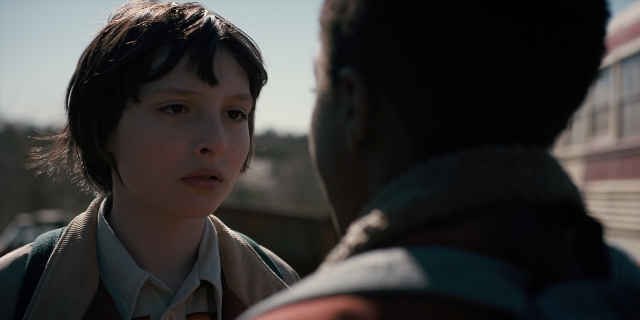 Medium shot frame from Stranger Things — standing, shirt, face