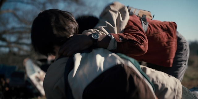 Wide shot frame from Stranger Things — standing, hug, person
