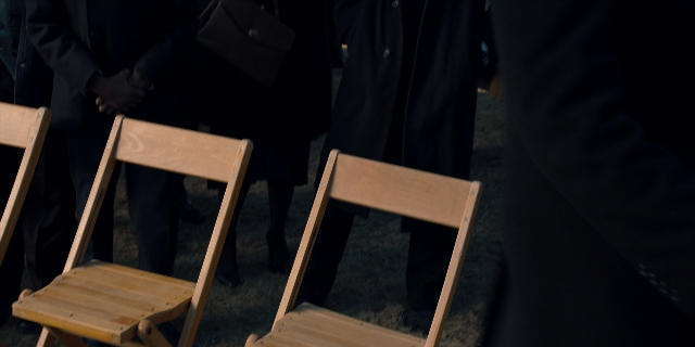 Wide shot frame from Stranger Things — standing, chair, person