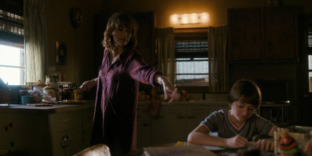 Wide shot frame from Stranger Things — sitting, standing, plate