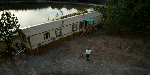 Wide shot frame from Stranger Things — walking, house, shirt