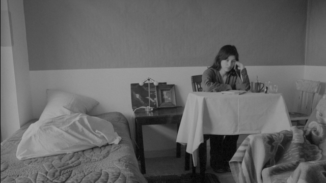 Frame from Je tu il elle — sitting, room, table