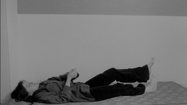 Frame from Je tu il elle — bed, shirt, person
