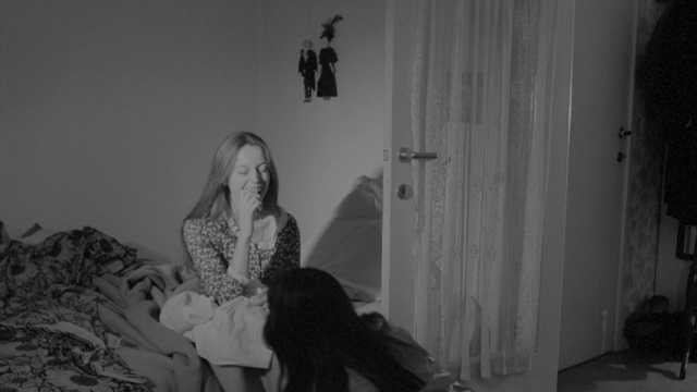 Wide shot frame from Je tu il elle — sitting, room, bed