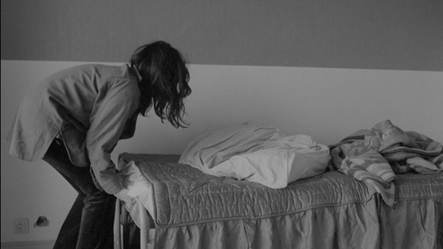 Wide shot frame from Je tu il elle — room, bed, shirt