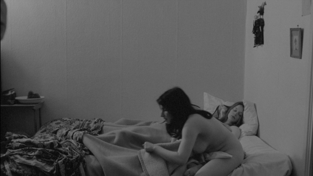 Wide shot frame from Je tu il elle — bed, face, lamp