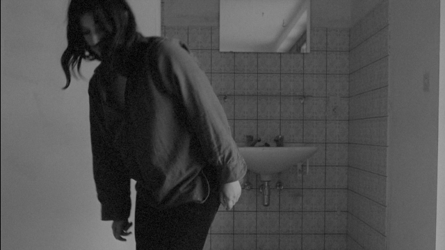 Wide shot frame from Je tu il elle — walking, mirror, jacket