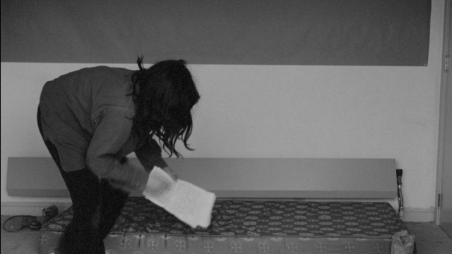 Wide shot frame from Je tu il elle — room, bed, shirt