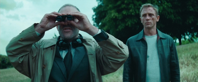 Wide shot frame from Layer Cake — standing, coat, tie