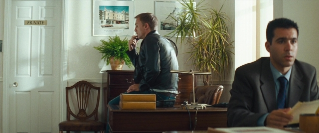 Wide shot frame from Layer Cake — sitting, room, table
