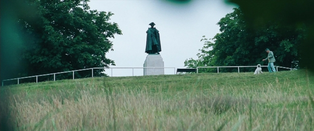 Wide shot frame from Layer Cake — standing, walking, hat