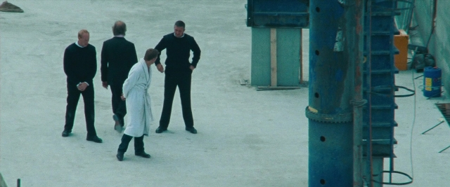 Wide shot frame from Layer Cake — standing, bag, person