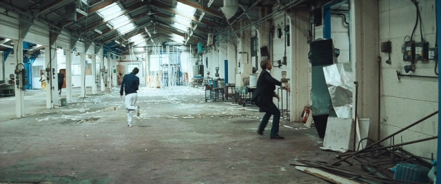 Wide shot frame from Layer Cake — walking, person, window