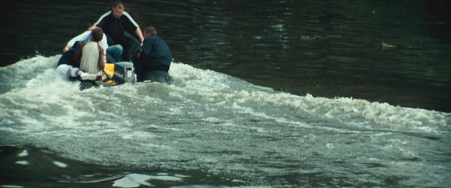 Frame from Layer Cake — sitting, standing, water
