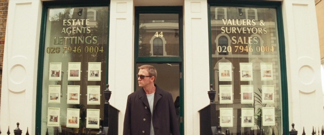 Wide shot frame from Layer Cake — standing, walking, coat