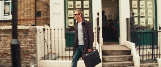 Wide shot frame from Layer Cake — walking, door, coat