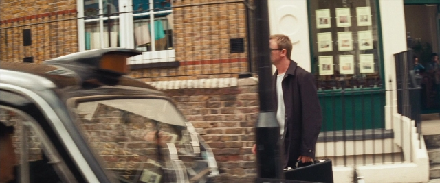 Wide shot frame from Layer Cake — walking, street, car
