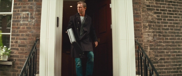 Wide shot frame from Layer Cake — standing, coat, hand