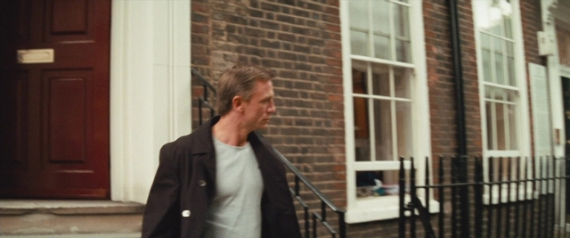 Wide shot frame from Layer Cake — walking, door, street
