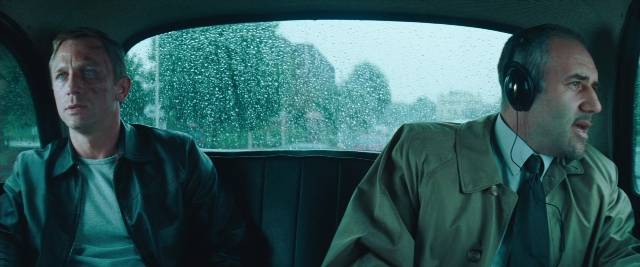 Wide shot frame from Layer Cake — sitting, car, coat