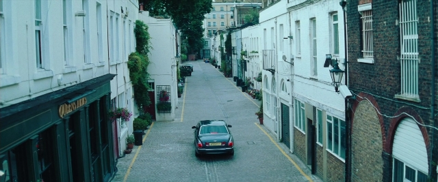 Frame from Layer Cake — street, car, restaurant