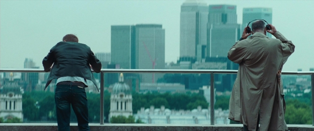 Frame from Layer Cake — standing, coat, skyscraper