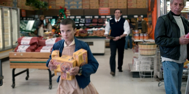 Wide shot frame from Stranger Things — walking, food, jacket