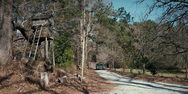 Wide shot frame from Stranger Things — street, car, land vehicle
