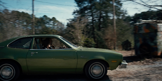 Wide shot frame from Stranger Things — street, car, wheel