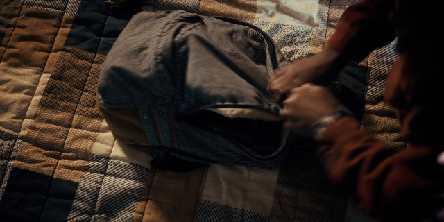Wide shot frame from Stranger Things — sitting, bed, shirt