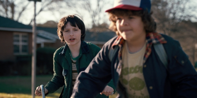 Wide shot frame from Stranger Things — walking, street, hat