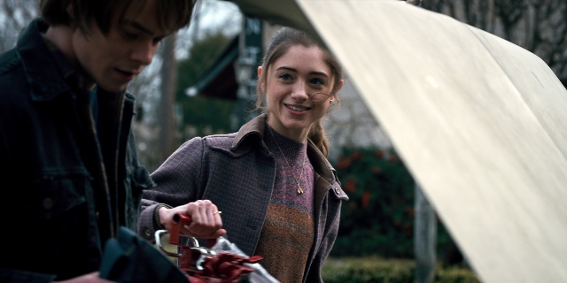 Wide shot frame from Stranger Things — standing, hand, jacket