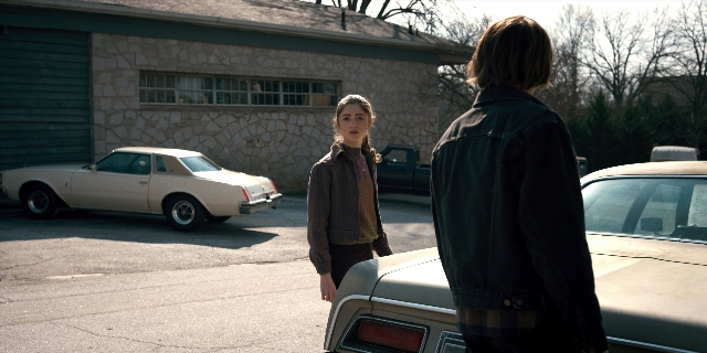 Wide shot frame from Stranger Things — standing, car, jacket