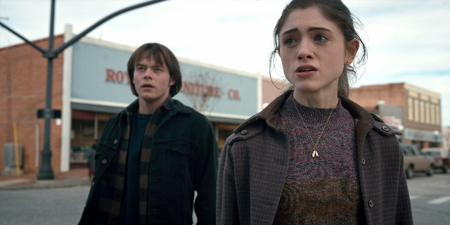 Medium shot frame from Stranger Things — standing, street, jacket