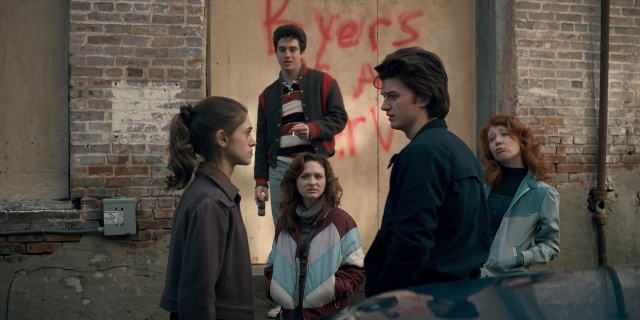 Wide shot frame from Stranger Things — standing, car, jacket