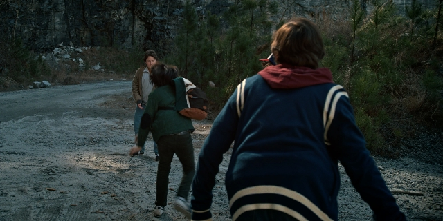 Wide shot frame from Stranger Things — walking, street, jacket