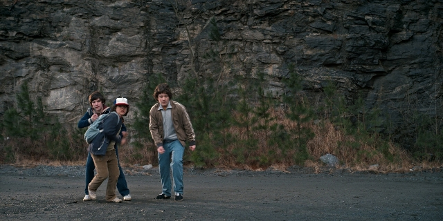 Wide shot frame from Stranger Things — walking, hat, face