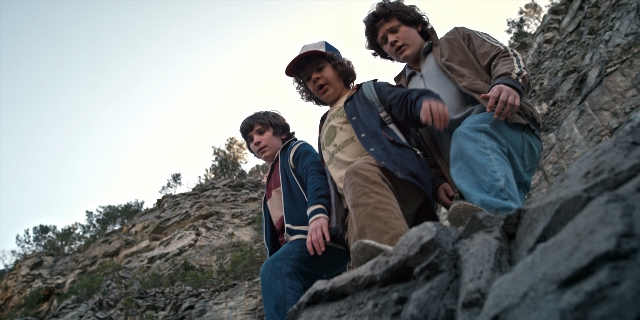 Wide shot frame from Stranger Things — sitting, hat, person