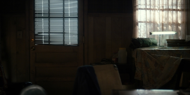 Wide shot frame from Stranger Things — room, table, door