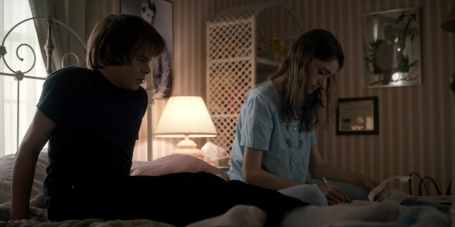 Wide shot frame from Stranger Things — sitting, room, dialogue