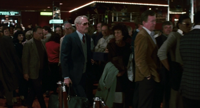 Wide shot frame from The Color of Money — standing, hand, suit