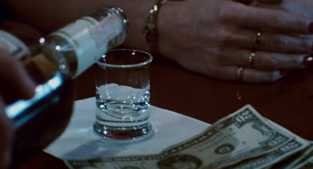 Wide shot frame from The Color of Money — table, hand, bottle
