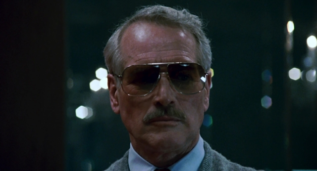 Close-up frame from The Color of Money — street, suit, tie