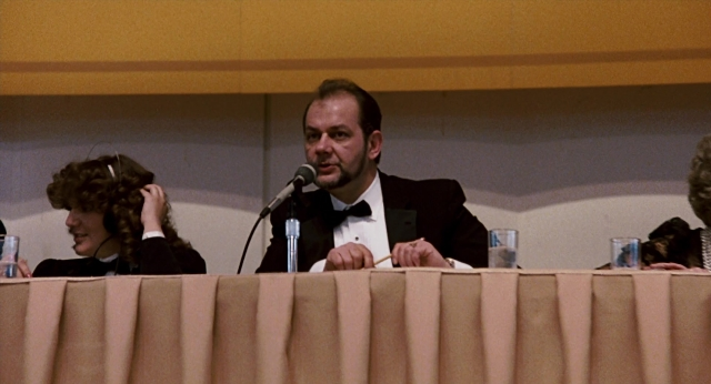 Wide shot frame from The Color of Money — sitting, table, dialogue