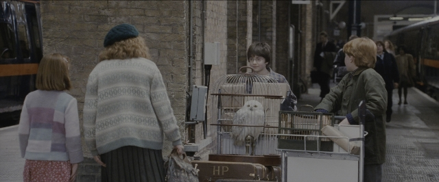 Wide shot frame from Harry Potter and the Sorcerer's Stone — standing, walking, street