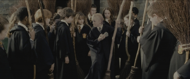 Wide shot frame from Harry Potter and the Sorcerer's Stone — standing, room, suit