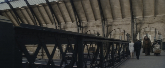 Wide shot frame from Harry Potter and the Sorcerer's Stone — walking, clock, train