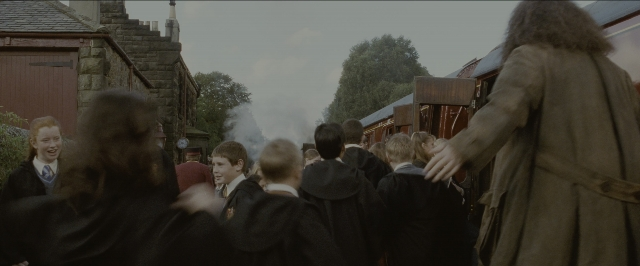 Wide shot frame from Harry Potter and the Sorcerer's Stone — standing, dialogue, suit