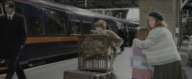Wide shot frame from Harry Potter and the Sorcerer's Stone — standing, walking, suit